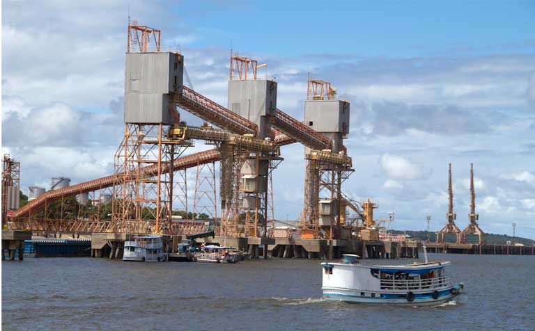 Symbols of today’s Amazon: a grain terminal and a riverboat. Brazil’s government and the ruralista industrial agriculture lobby insist that major transportation infrastructure is needed to meet future soy export demands — including two new railways and a 1,000-mile-long industrial waterway to move soy commodities to both South American coasts. This development could do considerable harm to Amazon forests and biodiversity. Photo: Walter Guimarães