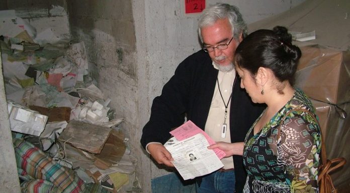 Alberto Fuentes, co-director of the Historical Police Archive of Guatemala, and Ana Lucía Cuevas reviewing documents found at what is now known as the Historical Archives of the National Police of Guatemala, c/o http://www.elecodeldolor.com/
