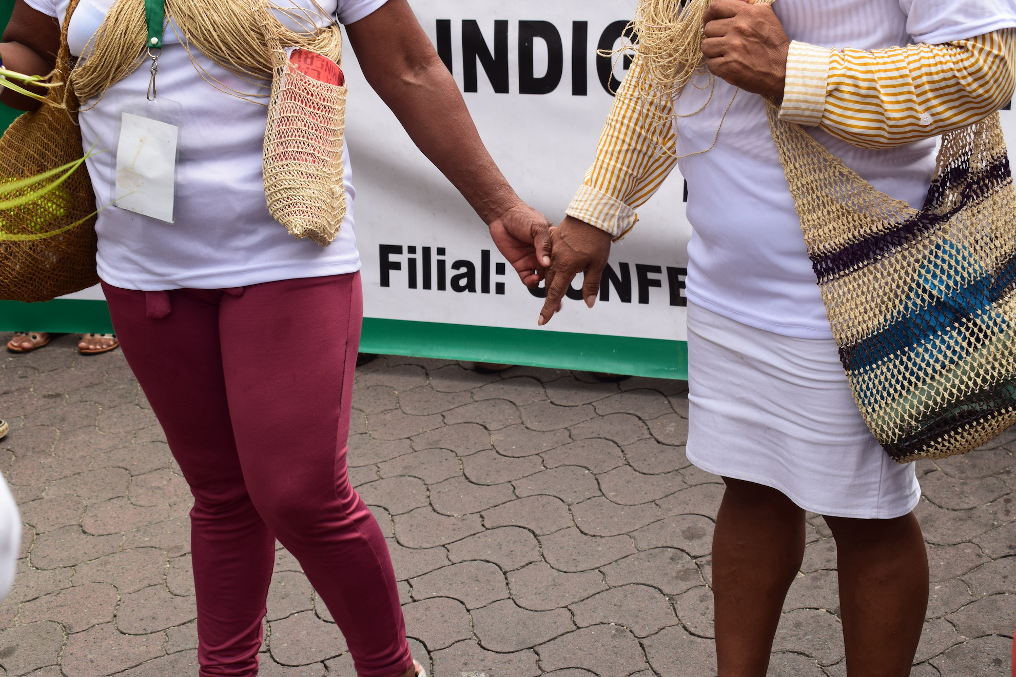 Waorani women and in hand in resistance at a march against mining in Napo, Ecuador