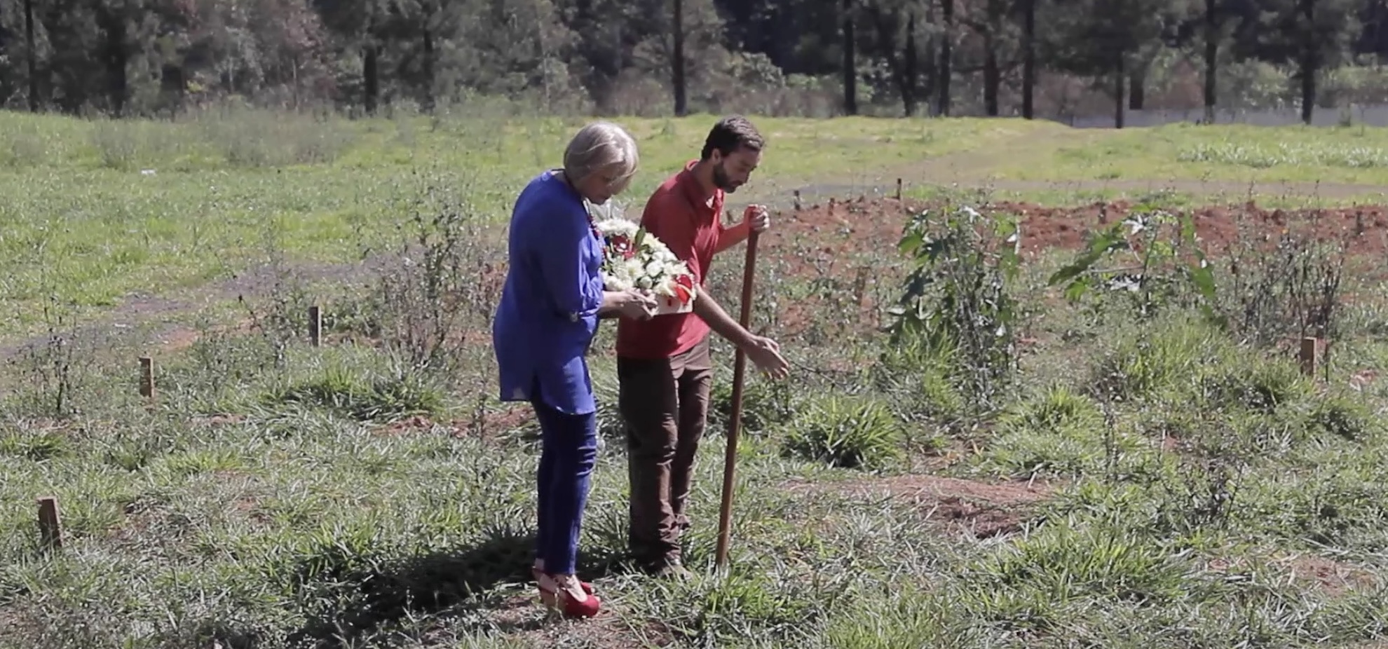 A gravedigger shows Vera Marchioro, mother of Luiz, where her son is believed to be buried in Perus cemetery (Photo: Calebe Simões)
