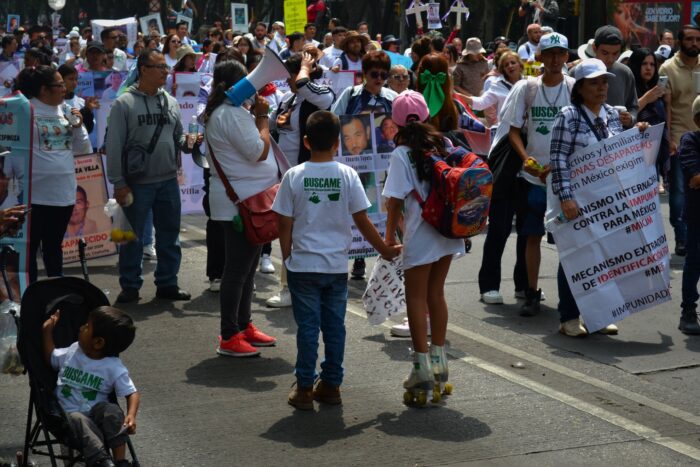 Two children hold hands at the Mother’s Day march for the disappeared in Mexico City. Photo- Charli McMackin