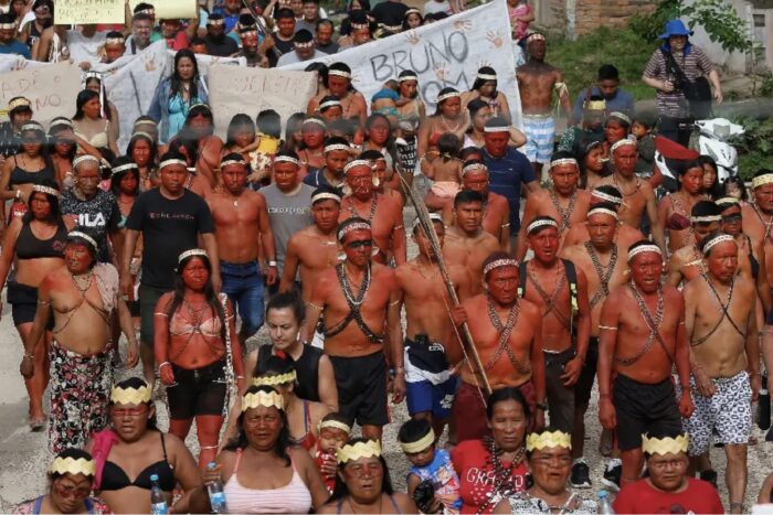 Indigenous demonstrators march together, with banners held above the crowd.