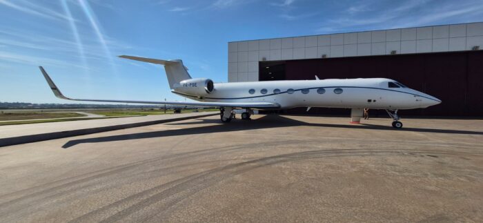 A white private jet parked outside an aircraft hangar, photographed by Brazil’s Federal Police during Operation Compliance Zero in August 2026.